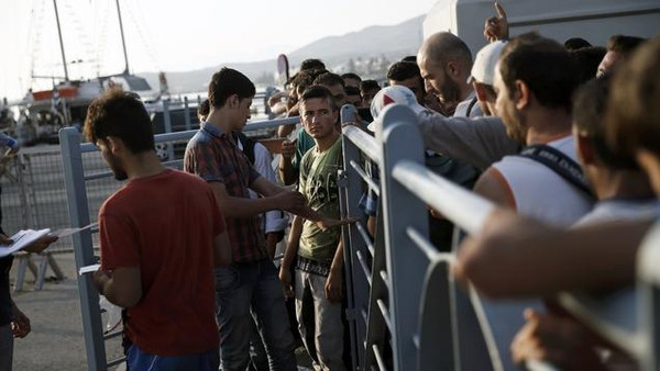 Syrian refugees go through passport control before boarding the passenger ship "Eleftherios Venizelos" at the port on the Greek island of Kos, August 16, 2015. The vessel will house more than 2500 refugees and migrants who entered the country from theTurkish coast and will be used as a registration center for migrants.The United Nations refugee agency (UNHCR) called on Greece to take control of the "total chaos" on Mediterranean islands, where thousands of migrants have landed. About 124,000 have arrived this year by sea, many via Turkey, according to Vincent Cochetel, UNHCR director for Europe. REUTERS/Alkis Konstantinidis